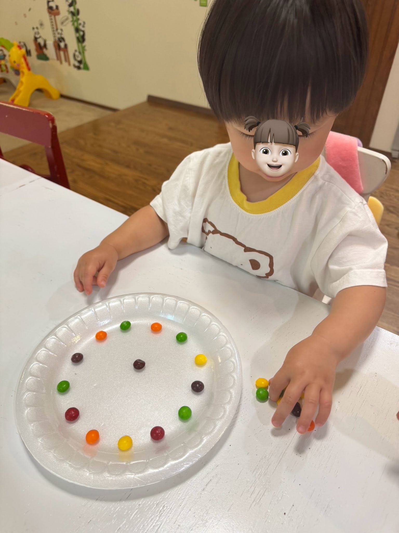 Panda Bear Childcare — child arranging colorful beads