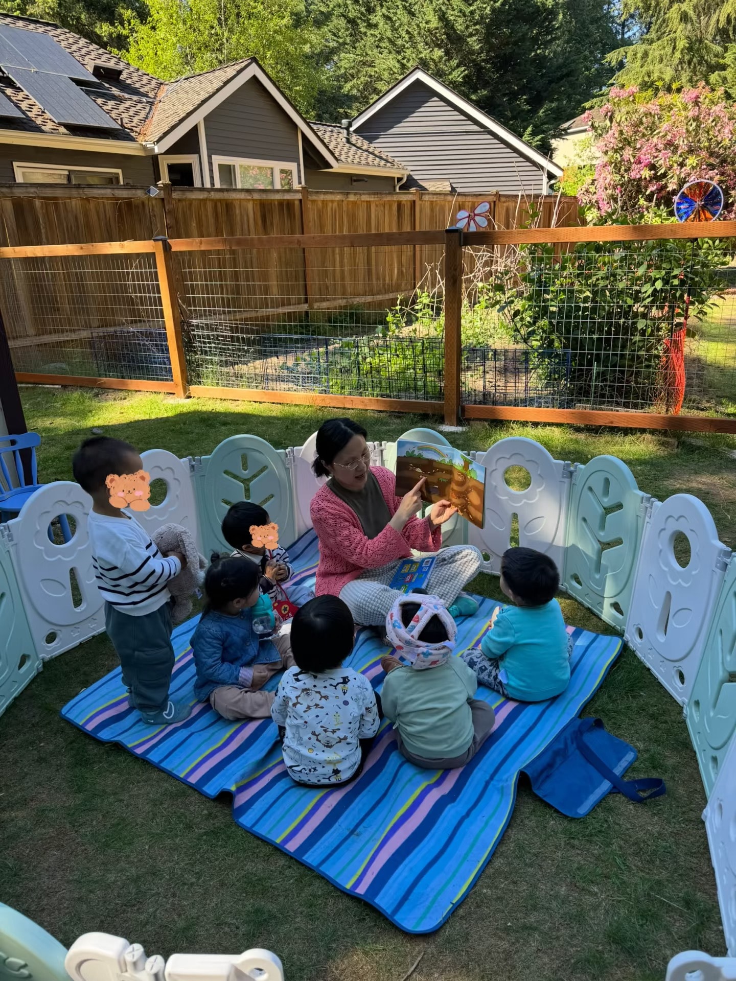 Panda Bear Childcare — teacher reading to children outdoor circle time