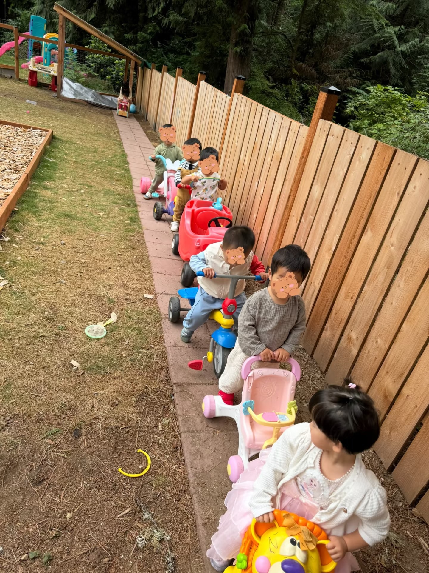 Panda Bear Childcare — toddlers riding toy cars outdoor playground