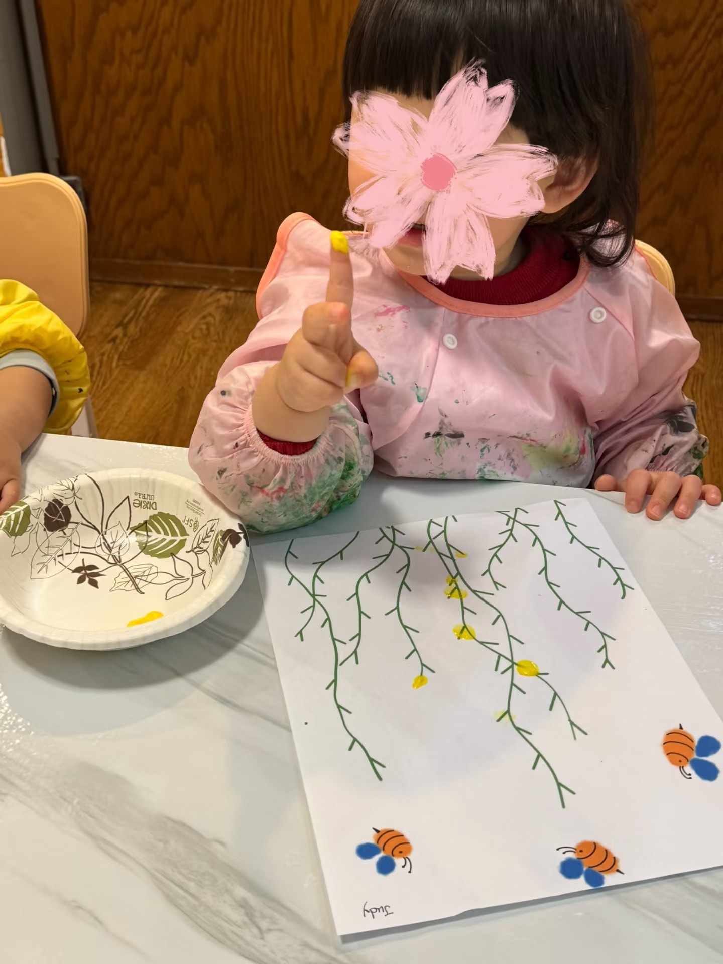 Panda Bear Childcare — child holding pink flower craft artwork
